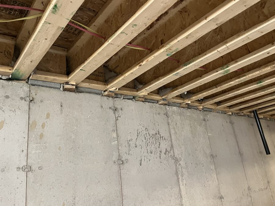 Floor joists bearing on a poured foundation wall